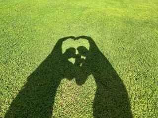 Silhouette of heart by gay couple