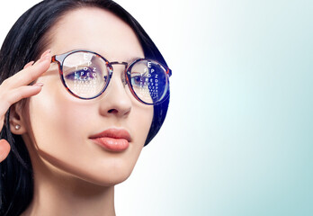 Fototapeta premium Woman with eye chart reflected in glasses. Optometry concept.