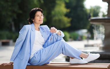 elegant  middle aged business woman  in a suit  walks and relaxing in street. Enjoying the little things. Lykke concept. Relaxation Concepts
