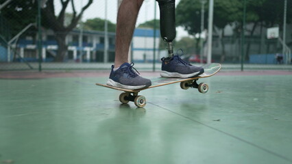 Disabled person riding skateboard with prosthetic leg. Athletic skateboarder amputee