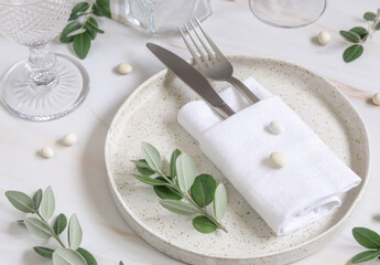 Elegant wedding Table setting decorated with eucalyptus branches and white pebbles close up