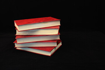 a stack of red books on a black background