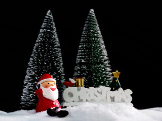 Santa Clause sitting on white snow on black background to created greeting card , Happiness and funny Christmas and  New Year concept