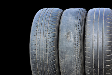 Obraz premium old worn out summer tire on black background