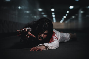 Halloween day horror concept. Asian woman zombie with blood creepy crawling move slowly creeping...