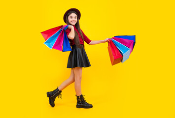 Sale and shopping concept. Teen girl holding shopping bags, isolated on studio background. Happy...