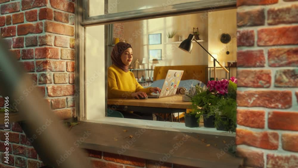 Poster smiling arab woman using laptop computer in her apartment on a warm sunny day. remote work concept w
