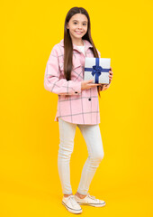 Fototapeta premium Teenager child with gift box, studio isolated background. Present for birthday, Valentines day, New Year or Christmas. Kid hold present box with gift ribbon bow.