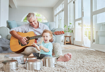 Child drummer with grandfather, guitar and music playing with pot drums in the living room at house. Happy, excited and smile of boy bonding and spending time with his elderly grandpa in family home. - Powered by Adobe