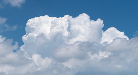 Naklejka na ściany i meble Cumulonimbus cloud against blue sky close up, cloud development