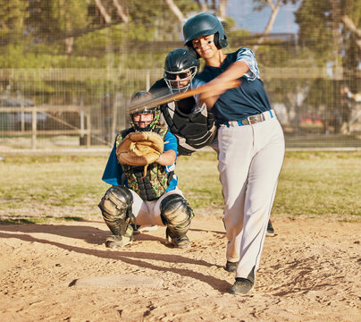 Baseball player, female athlete and swinging bat with sports technique or skill while playing a competitive game or match on a pitch or field. Fit female with a catcher doing exercise and recreation - Powered by Adobe