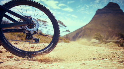 Bike, sport and adventure with a bicycle wheel in the dirt for adventure, risk or freedom and a...