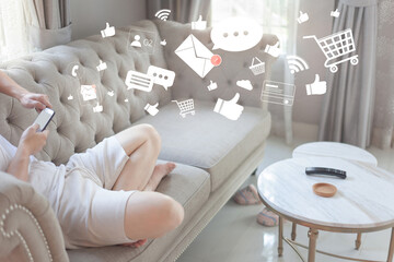 Connection application technology concept. Man relaxing and shopping online on Smartphone at home. Person using a social media on mobile phone with icons of message, like, comment, wifi, cart,