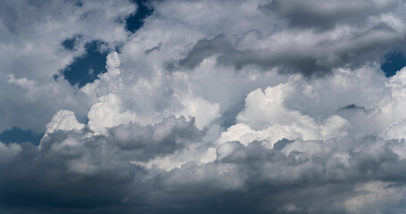 Fototapeta na wymiar Big bright clouds against dark blue sky, cloud in dramatic light, panoramic view