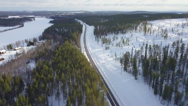 Car Coming From South And Camera Going To South. Cinematic Aerial Drone Forward Move.  Couple Of Houses In Middle Of The Forest By The Ice Covered River.