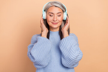 Photo of dreamy adorable lady pensioner dressed blue pullover enjoying music closed eyes isolated...