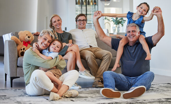 Happy, family and smile for love, care and playful happiness together in the living room at home. Portrait of people in joyful generations smiling and bonding fun with children and grandparents