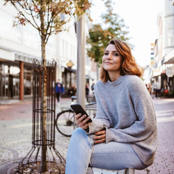 Young woman with smartphone downtown
