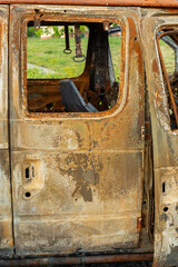 Damaged and destroyed civilian car with shrapnel holes from Russian missile in a war zone in...