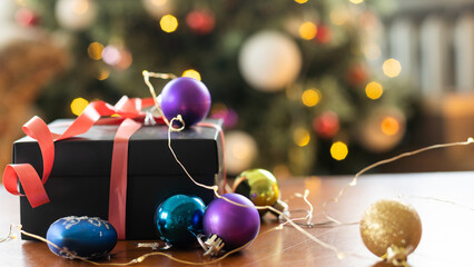 Gift boxes with a red bow against a background bokeh of twinkling party lights. Luxury New Year...