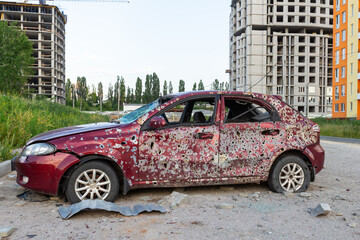 Damaged and destroyed civilian car with shrapnel holes from Russian missile in a war zone in...