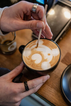 Barista making a bear face shape on top of a cappuccino
