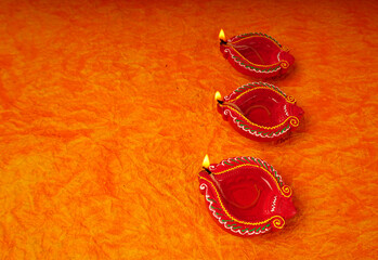 Oil lamps (Clay diya) lit on colorful rangoli during diwali celebration.Greeting Card Design Indian Hindu Light Festival called Diwali.