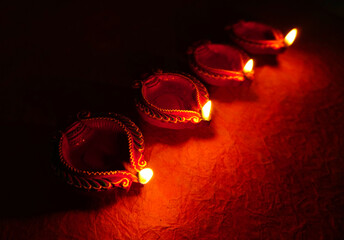 Oil lamps (Clay diya) lit on colorful rangoli during diwali celebration.Greeting Card Design Indian Hindu Light Festival called Diwali.