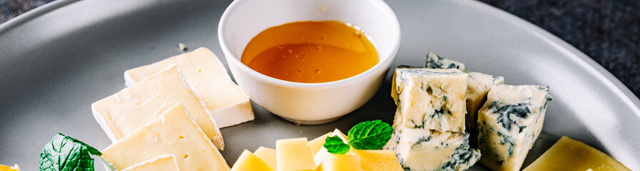 different types of cheese and honey on a plate