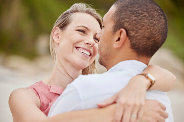 Fototapeta premium A happy, love and diversity couple hug outside on their honeymoon, vacation or holiday. Man and woman together in relationship embrace, romantic bond and loving on a sunny day celebrate anniversary.
