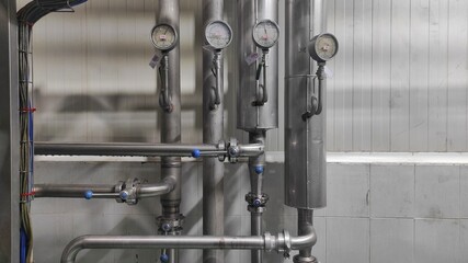 Industrial background of stainless steel pipes and gauges in production room of factory
