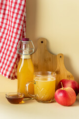 Cup and Bottle with Apple Cider with Cinnamon and Honey Yellow Background Seasonal Apple Mulled Wine Vertical