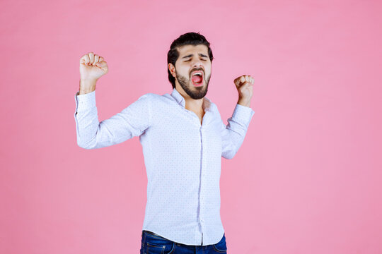 Man in a white shirt looks tired and sleepy