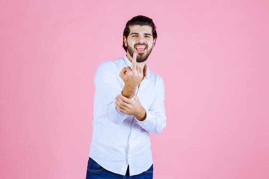 Man in a white shirt showing his middle finger
