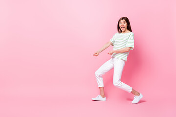 Fototapeta na wymiar Full length photo of cheerful crazy girl dressed striped stylish clothes hold rope empty space rejoice isolated on pink color background