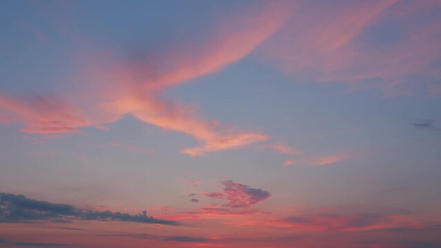 High cloud, twilight time. Different shades clouds across darkening blue horizon. Timelapse.