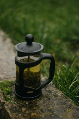 a kettle with green tea in autumn rainy weather
a teapot with green tea 