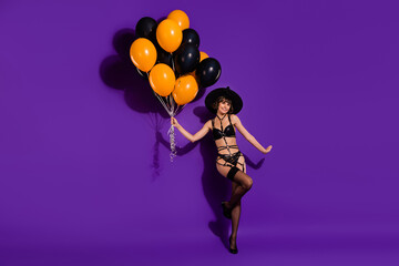 Full length body size view of attractive trendy cheery girl holding balls posing isolated over bright violet purple color background