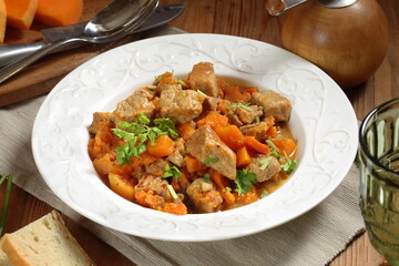 Roast pork with pumpkin on wooden background