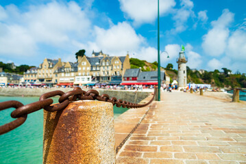 The elegant marina of Cancale, Brittany, France. Dock with a chain in the foreground. Facade of...