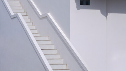 Sunlight on surface of concrete staircase outside of white vintage building in perspective side view