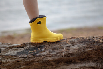 Obraz premium Yellow boot stay on wood and sea backround.