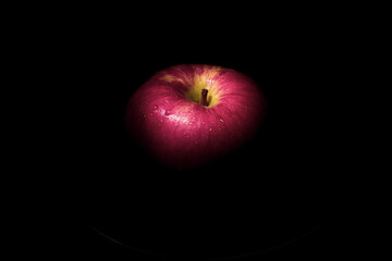 fresh red apple On a black background with water droplets, lights are falling with space for text.