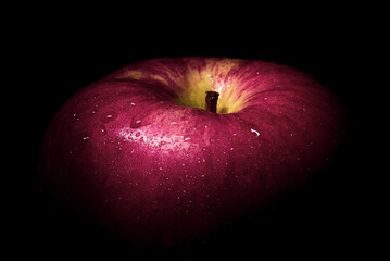 fresh red apple On a black background with water droplets, lights are falling with space for text.