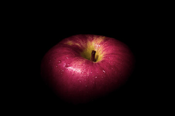 fresh red apple On a black background with water droplets, lights are falling with space for text.