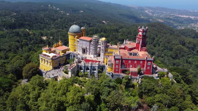 Aerial drone view of Park and National Palace of Pena in Sintra, Portugal during a sunny day. Unesco World Heritage. Historic visits. Holidays and summer vacation tourism. Colorful palace. 
