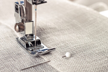 Modern sewing machine presser foot with linen fabric and thread, closeup, copy space. Sewing...