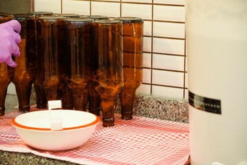 Process of beer brewing in the kitchen at home with beer bottles