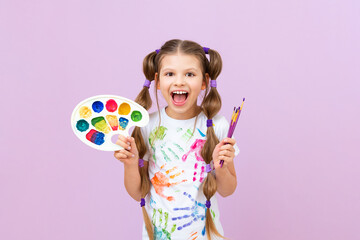 Development of children's creativity and drawing with paints. A beautiful girl with paints, brushes...