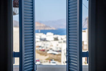 Naxos island, Cyclades Greece. View from the open wooden shutters window the blur island.